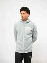 Campera de entrenamiento Umbro con capucha, cierre frontal completo y bolsillo en el pecho de nylon con cierre. Presenta una textura de tejido en relieve y logo de la marca estampado en el bolsillo.