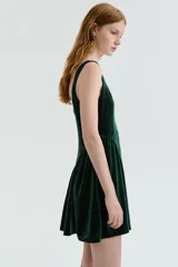 Vestido corto de velour color verde oscuro, con escote cuadrado, breteles anchos y falda acampanada con frunces laterales.