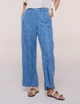 Pantalón wide leg de lyocell color azul con estampado paisley, cintura elástica y bolsillos laterales. Cuenta con una tira lateral decorativa con diseño ornamental.