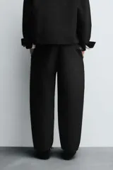 Pantalón de corte relaxed fit con pinzas delanteras, confeccionado en una mezcla de algodón, lino y lyocell. Presenta bolsillos laterales, bolsillos traseros de vivo y cierre frontal con cremallera y botón.