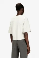Camiseta corta Diesel T-Cropyn-S1 de color blanco, corte holgado con hombros caídos y mangas cortas. Presenta un estampado sutil en relieve en forma de collar de cadena alrededor del cuello.