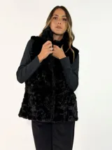 Chaleco de piel sintética en color negro, con cuello alto y diseño sin mangas. Presenta una textura suave y voluminosa, ideal para climas fríos.