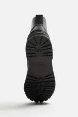 Bota negra de cuero con cordones, caña media y suela track.