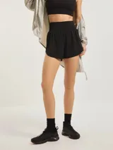 Short deportivo de color negro con calza biker integrada, confeccionado en tejido técnico ligero y elástico, con cintura alta y ajuste cómodo.