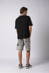 Bermuda de jean de corte mom, estilo carpintero, con lavado ácido gris claro. Presenta costuras marcadas, bolsillos funcionales y detalles de refuerzo en los laterales.