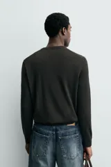 Jersey de punto de corte regular fit, confeccionado en hilatura de lana. Presenta cuello en pico, manga larga y acabados en rib.