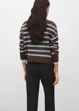 Sweater de punto con diseño de rayas horizontales en tonos marrón y celeste, cuello alto y manga larga. Presenta un corte oversize y acabado suave.