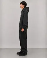 Canguro con capucha de algodón y poliéster, color negro con efecto lavado. Presenta bolsillo frontal tipo canguro, capucha con cordones ajustables y detalles gráficos estampados en el pecho.