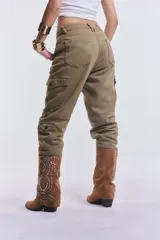 Pantalón cargo tipo babucha de denim en color verde militar, con bolsillos laterales con solapa y puños elásticos en los tobillos.