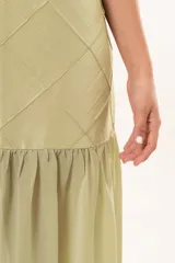 Vestido largo verde con cuello halter, cuerpo con diseño de rombos pespuntados y falda fluida transparente.
