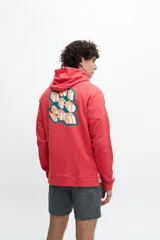 Buzo canguro de algodón color rojo, con capucha, manga raglan y bolsillo canguro frontal. Presenta un diseño gráfico tridimensional en la espalda con texto en tonos turquesa y naranja.