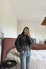Sweater de punto grueso con textura marcada, de silueta relajada y diseño amplio, con cuello redondo y puños acanalados.