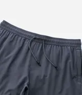 Bermuda de running para hombre, color beige claro, confeccionada en microfibra tecnológica. Presenta cintura elástica con cordón ajustable y bolsillos funcionales.