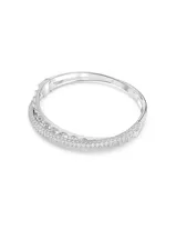 Brazalete rígido plateado con doble banda, una con piedras de talla baguette y otra con pavé de cristales blancos. Cierre a presión.