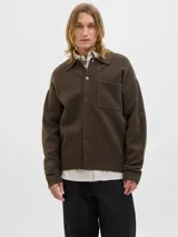 Cardigan de punto color marrón oscuro, con cuello tipo polo, cierre frontal con botones y un bolsillo aplicado en el pecho. Presenta mangas largas con hombros caídos y puños acanalados.
