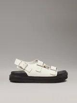 Sandalias de piel lisa color blanco con suela de goma negra, tiras anchas con hebillas metálicas ajustables y plantilla moldeada.