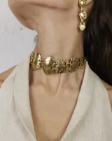 Gargantilla de diseño artesanal compuesta por eslabones metálicos con textura orgánica y acabado irregular. El diseño se ajusta al cuello mediante un cordón regulable.