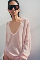 Jersey de punto fino negro con escote en V profundo y manga larga con puños ajustados.