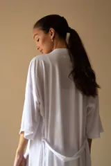 Bata estilo kimono de algodón en color gris azulado, con mangas al codo y largo por encima de la rodilla. Incluye lazo de ajuste en la cintura.