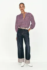 Blusa de cuello redondo y manga larga abullonada, con estampado de cuadros en tonos rosados, violetas y blancos. Cierre frontal con botones.