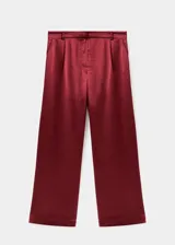Pantalón wide leg de tiro medio en tejido satinado color bordó, con pinzas delanteras, trabillas, bolsillos laterales y cierre oculto con botón, gancho y cremallera.