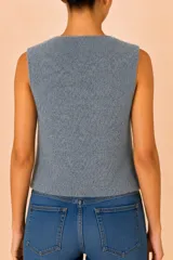Chaleco de punto en color gris, con cuello redondo y cierre frontal de dos botones oscuros. Diseño sin mangas y corte recto.