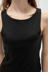 Musculosa de corte al cuerpo con cuello redondo y diseño sin mangas, confeccionada en tejido liso.