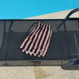 Short de baño con rayas verticales en verde y negro, con cintura elástica ajustable con cordón y logo estampado en la pierna.