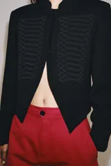 Blazer negro ZW Collection con cuello perkins, manga larga con vuelta en los puños y bajo asimétrico. Presenta detalles de alamares bordados en el frente.
