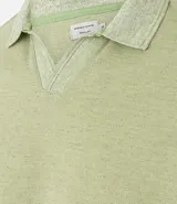 Polo de manga corta color verde salvia, con cuello polo y escote en V con borde de punto contrastante. Presenta una textura tejida sutil.
