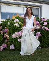 Collar artesanal con dije central de metal con textura orgánica irregular que evoca una ostra. El dije está montado sobre un cordón de algodón natural, permitiendo un uso versátil y regulable.