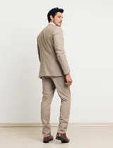 Ambo de dos piezas color tostado, compuesto por un saco entallado de dos botones y pantalón de vestir de corte recto.