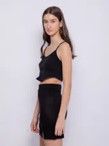 Minifalda negra de tejido de punto con pretina elástica y abertura lateral.