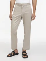 Pantalón de vestir color beige claro, de corte recto y ajuste regular, con cierre de botón y cremallera.