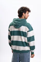 Canguro con capucha de corte holgado, con diseño de rayas horizontales anchas en color verde y beige. Cuenta con bolsillo frontal tipo canguro y puños y ruedo acanalados.