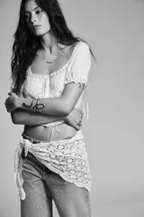 Brazalete rígido metálico color bronce envejecido con forma de serpiente enrollada. La superficie del brazalete tiene una textura de escamas en relieve.