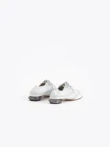 Zapato de cuero vacuno color blanco con acabado arrugado, diseño estilo oxford con detalles perforados, cordones y tacón bajo decorado con pedrería.