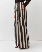 Pantalón amplio de algodón con rayas verticales en tonos negros y blancos, cintura elastizada, corte fluido y grandes bolsillos laterales con solapa de estilo cargo.