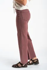 Pantalón de jean estilo wide leg de tiro alto, con corte recto y amplio, en color bordó con efecto lavado. Presenta bolsillos laterales y traseros, con ruedo desflecado.