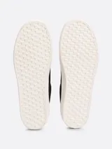 Zapatillas Tommy Hilfiger Essential de plataforma, color negro, confeccionadas en lona de algodón. Presentan suela de goma blanca, interior de poliéster, plantilla extraíble y logo metálico en la lengüeta y el lateral.
