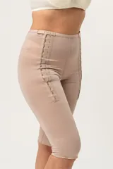 Calza capri color piel, de tela de faja de alta contención, con broches laterales reforzados con dos medidas y orificio sanitario en la entrepierna.