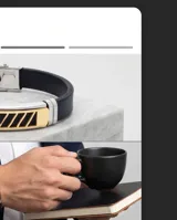 Pulsera de diseño moderno compuesta por una banda de goma negra y una placa central de acero inoxidable con detalles en baño de oro y aberturas geométricas. Incluye cierre de seguridad de acero.