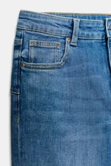 Jeans bootcut de tiro medio color azul oscuro, con cinco bolsillos y pespuntes a contraste. Cierre frontal con cremallera y botón.