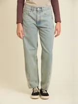 Jean de denim en corte balloon fit, con tiro medio y lavado claro. Presenta costuras laterales curvadas que definen su silueta amplia y relajada.