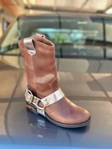 Bota de cuero marrón con estribo desmontable plateado.