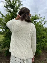 Cardigan tejido a mano color crudo, con solapa en el escote y punto delicado.