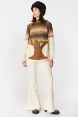 Sweater de tejido de punto con diseño artístico de un árbol en la parte inferior y franjas horizontales multicolores en la parte superior. Presenta cuello redondo, mangas largas y puños acanalados.