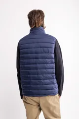 Chaleco puffer negro con cierre frontal y cuello alto.