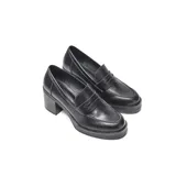 Zapato tipo mocasín de plataforma con taco alto y ancho, confeccionado en material sintético liso con acabado negro. Presenta un diseño clásico con antifaz tradicional en la capellada y punta redondeada.