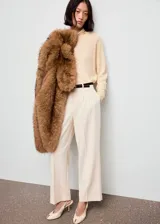 Jersey de punto fino color beige, con cuello alto y mangas largas de diseño recto.